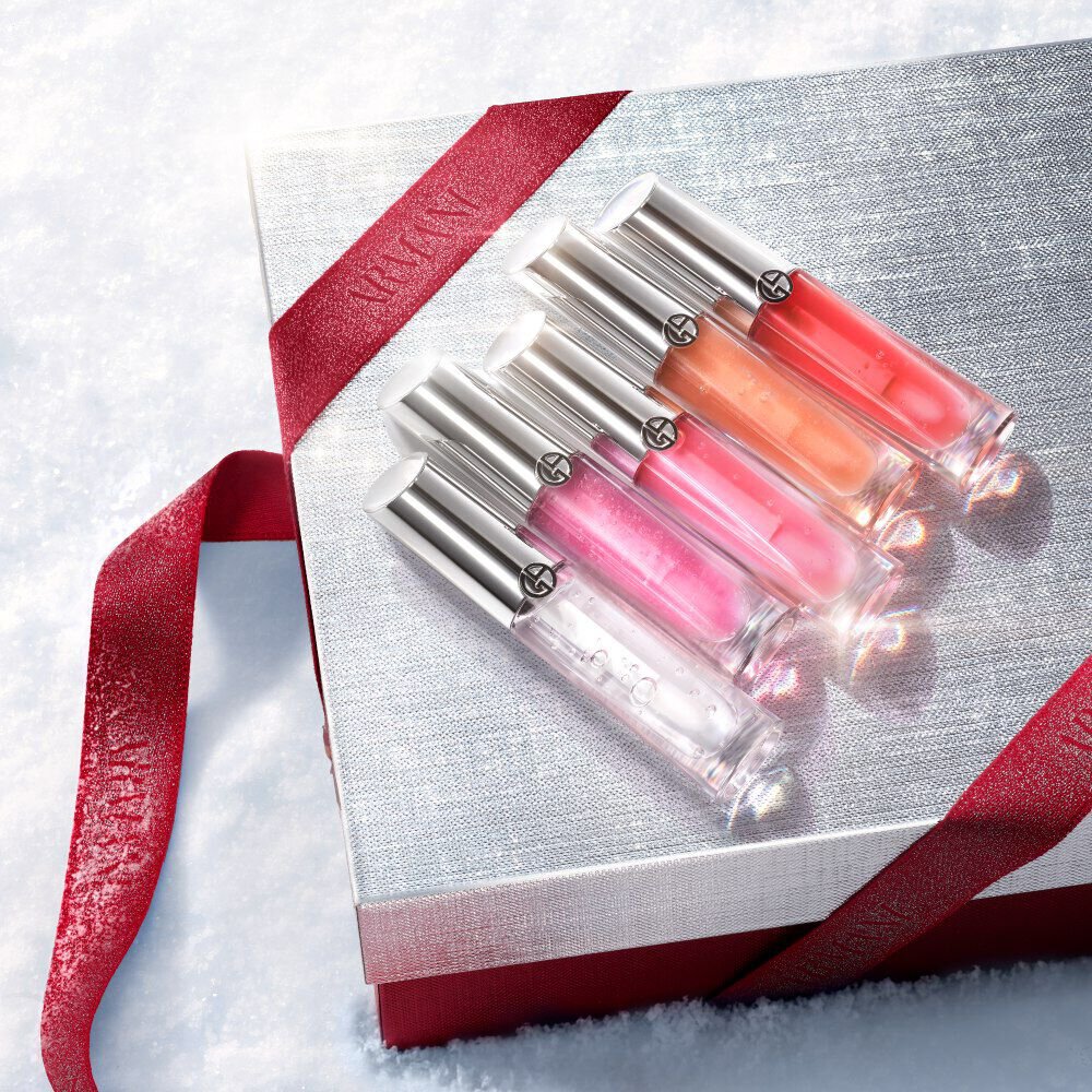Armani beauty Prisma Glass lip glosses on a silver gift box with red accents.