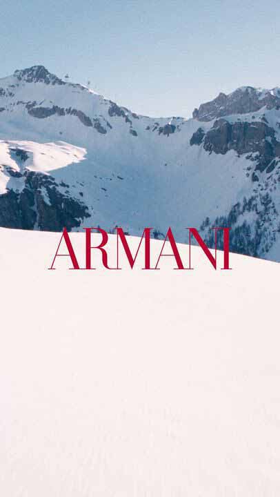 Cinematic Giorgio Armani winter holiday video featuring Madisin Rian and Xavier Serrano in a snowy alpine resort setting, showcasing luxury Armani Beauty gift sets and fragrances like Emporio Armani amidst scenic mountain landscapes.