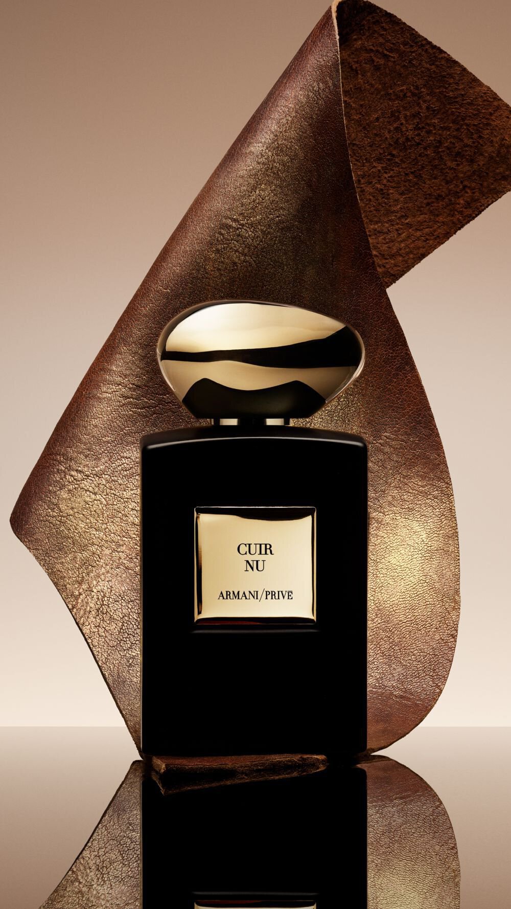 Armani/Prive Cuir Nu: sleek black bottle with a sculptural gold cap, set against a rich leather backdrop, embodying the fragrance’s luxurious ambery leather character and refined elegance.