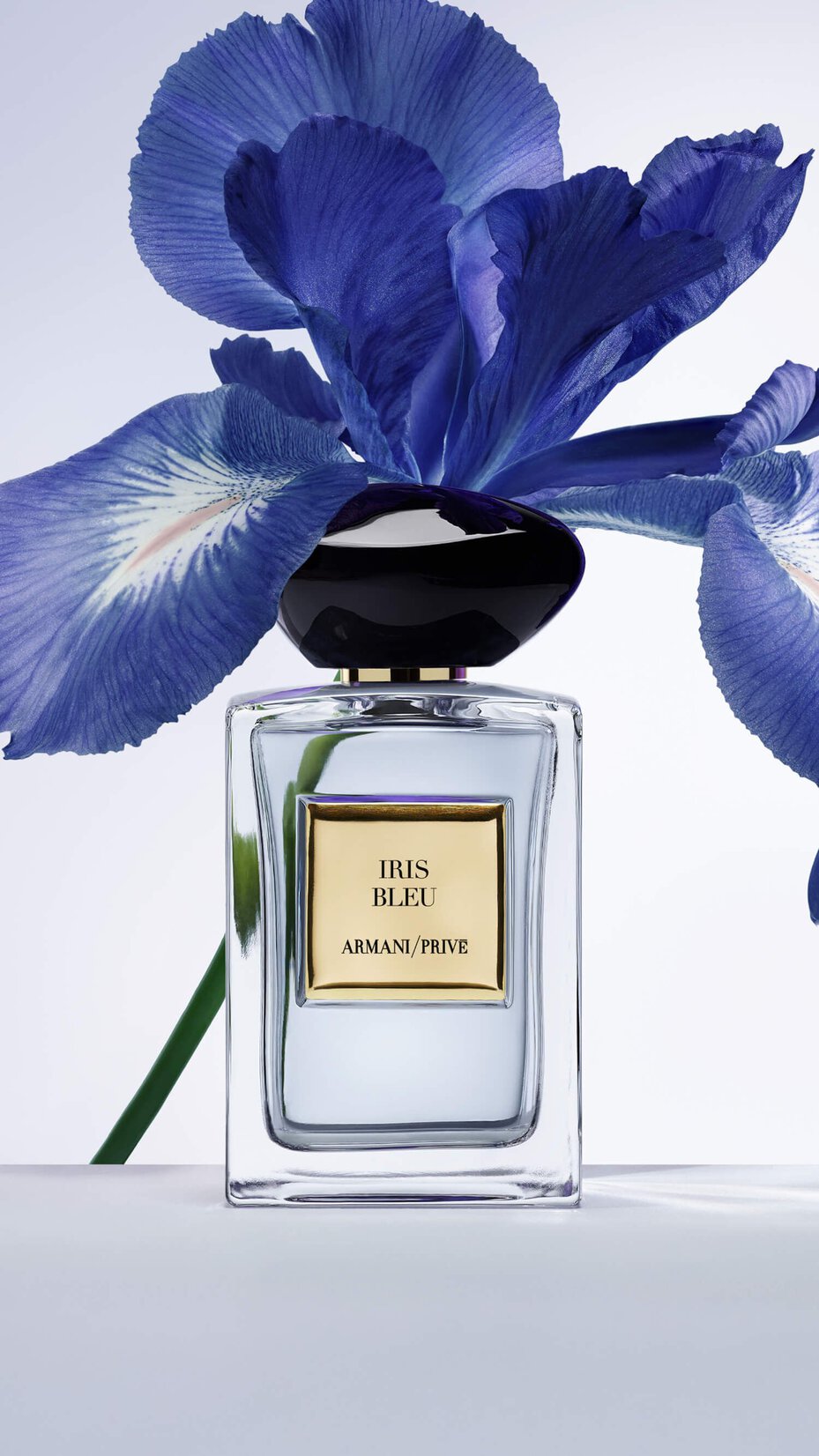 Armani/Prive Iris Bleu: elegant fragrance bottle set against a striking blue iris flower, capturing the essence of refined floral luxury and sophisticated artistry.
