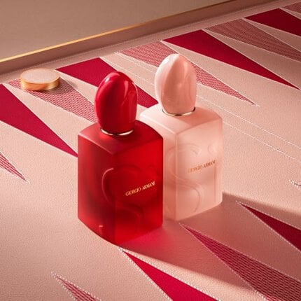Armani Mother's Day display featuring SI NUDE BLOOM and SI PASSIONE BLOOD perfumes on a textured pink backgammon board with red triangular patterns and gaming pieces.