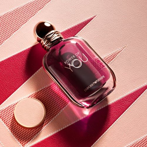 Armani Mother’s Day shot of "Power of You" fragrance on a pink textured backgammon board with sharp red geometric triangles and warm lighting.