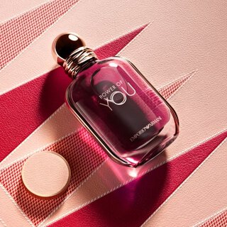 Armani Mother’s Day shot of "Power of You" fragrance on a pink textured backgammon board with sharp red geometric triangles and warm lighting.