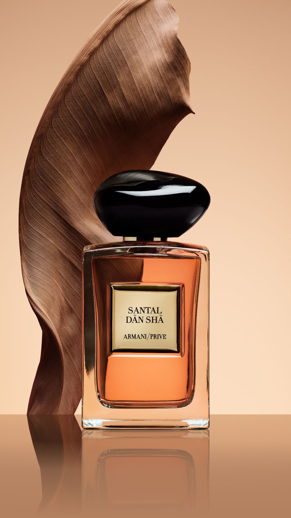 Armani/Prive Santal Dān Shā: the fragrance bottle elegantly framed by a sculptural swirl of sandalwood, capturing the essence of refined woody luxury.