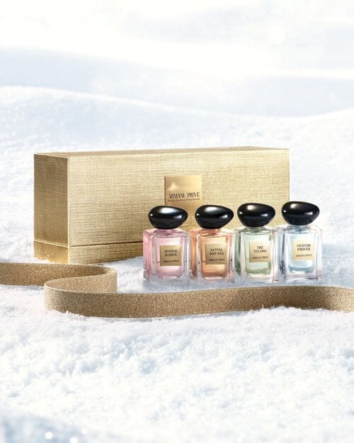 Armani/Prive Haute Couture fragrances in a golden coffret on snow for the holiday season.