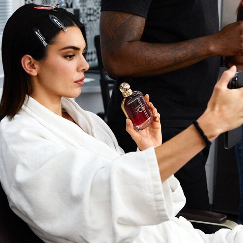 Behind the scenes with Kendall Jenner holding the ARMANI POWER OF YOU perfume bottle while getting ready, capturing an authentic and radiant moment.