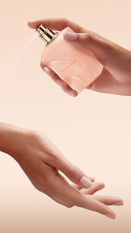 Hand spraying Giorgio Armani Si Nude Bloom perfume onto the wrist.