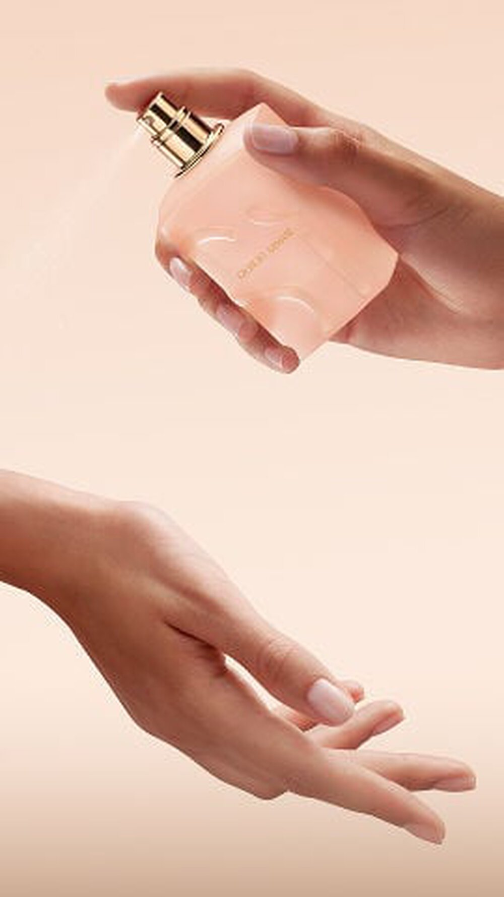 Hand spraying Giorgio Armani Si Nude Bloom perfume onto the wrist.
