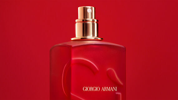 Close-up of the Giorgio Armani Si red bottle spray nozzle on a red background.