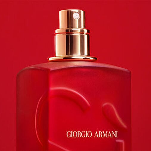 Close-up of the Giorgio Armani Si red bottle spray nozzle on a red background.