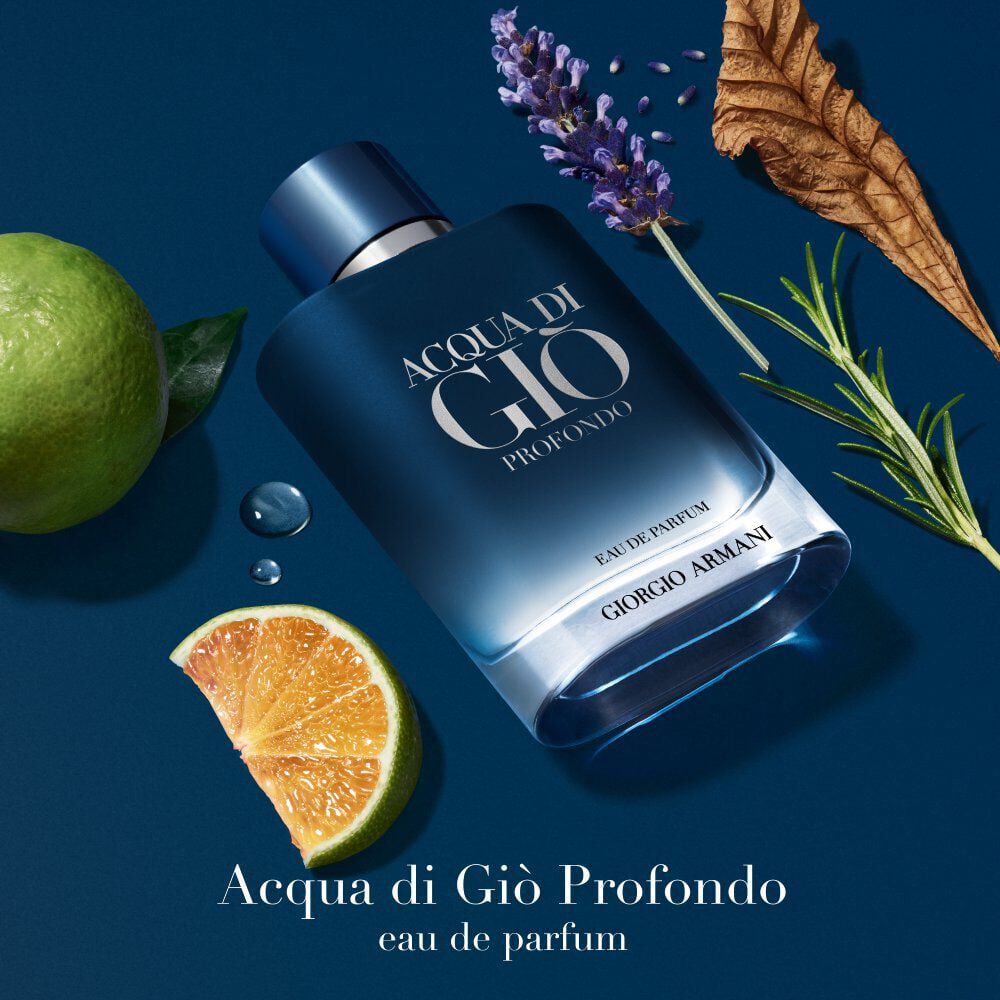 Acqua di Gio Profondo Eau de Parfum by Giorgio Armani, deep blue bottle surrounded by green mandarin and lavandin flowers on a water-drenched surface — men's aquatic fragrance.