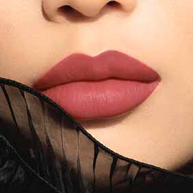 Close-up of lips wearing ARMANI LIP MAESTRO shade 140 Mysterious Nude, framed by black sheer fabric.