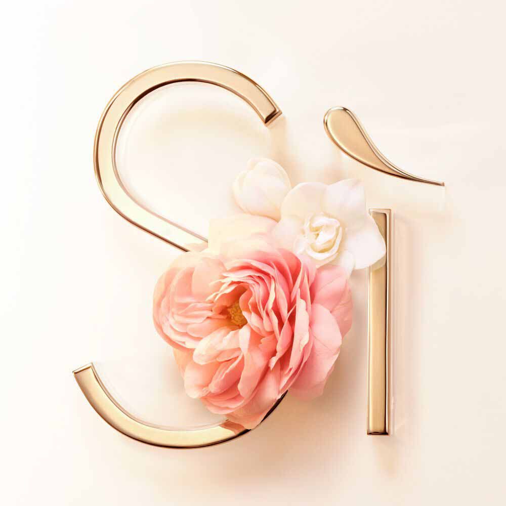 Pink rose de mai bloom against the gold Si signature on a blush background — rose de mai and freesia heart notes of Si Eau de Parfum by Giorgio Armani.