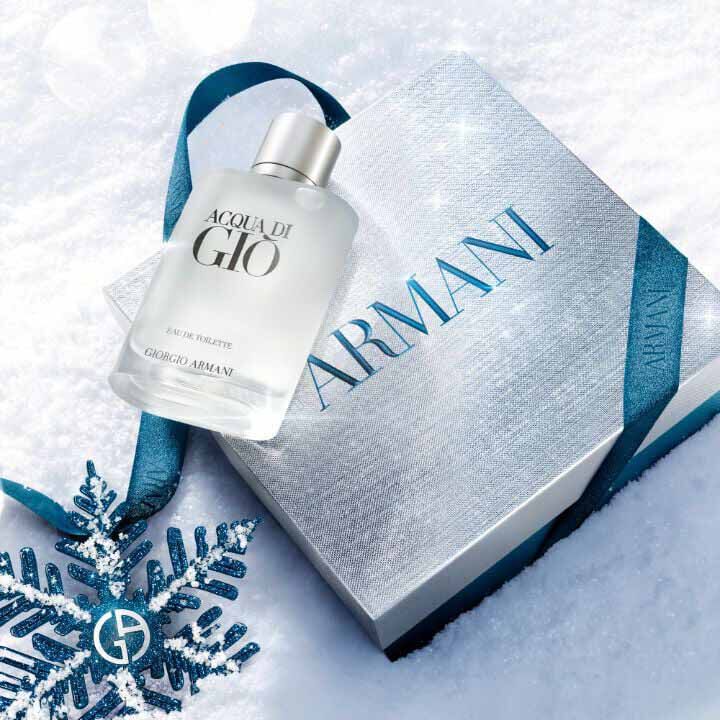 Acqua di Gio Eau de Toilette 50ml gift set in a silver Armani gift box with blue ibbon, styled on a snowy surface with a blue glitter snowflake — Giorgio Armani holiday fragrance gift for men.