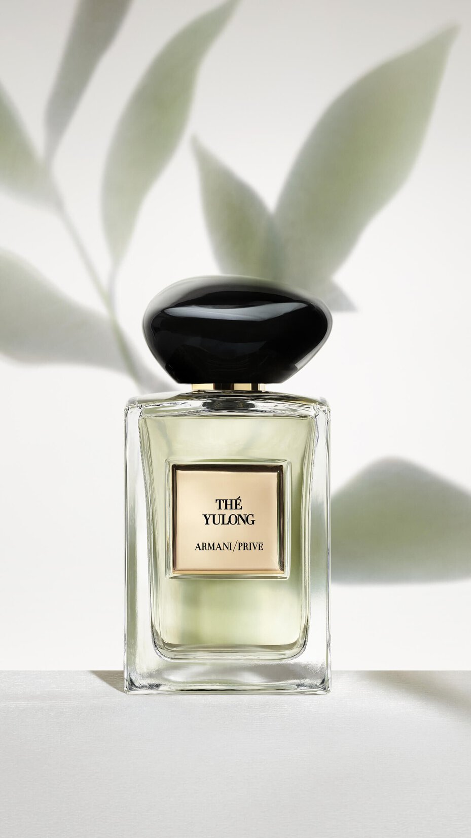 Armani/Prive The Yulong: refined perfume bottle set against a soft, leafy shadow backdrop, evoking the fragrance’s fresh, serene, and sophisticated character.