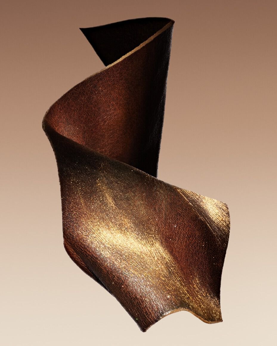 A cuir, twisted sculpture with brown and gold tones