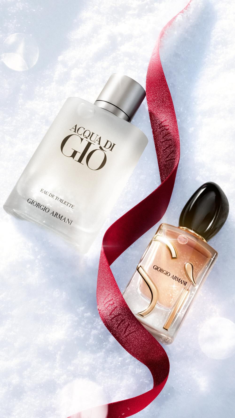 Giorgio Armani fragrances on snow with a red ribbon for the holiday season. 