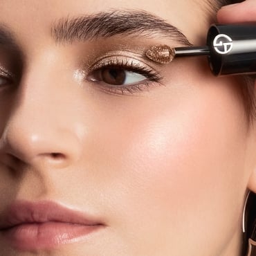 A model's face with two shades of liquid foundation or concealer applied in V-shapes on their cheek and jawline.