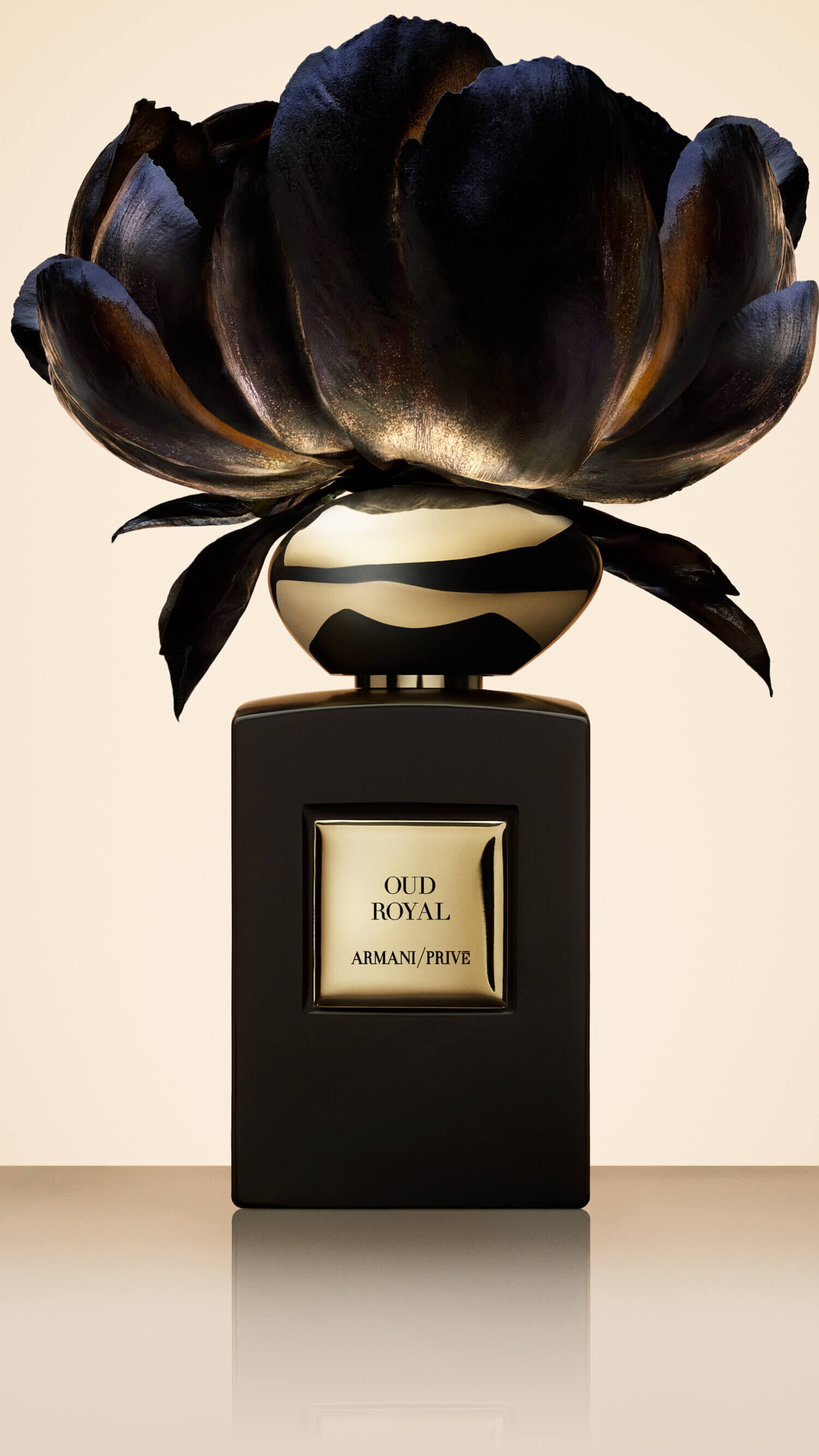 Bottle of Armani/Prive Oud Royal  against a light beige background with an opulent flower.