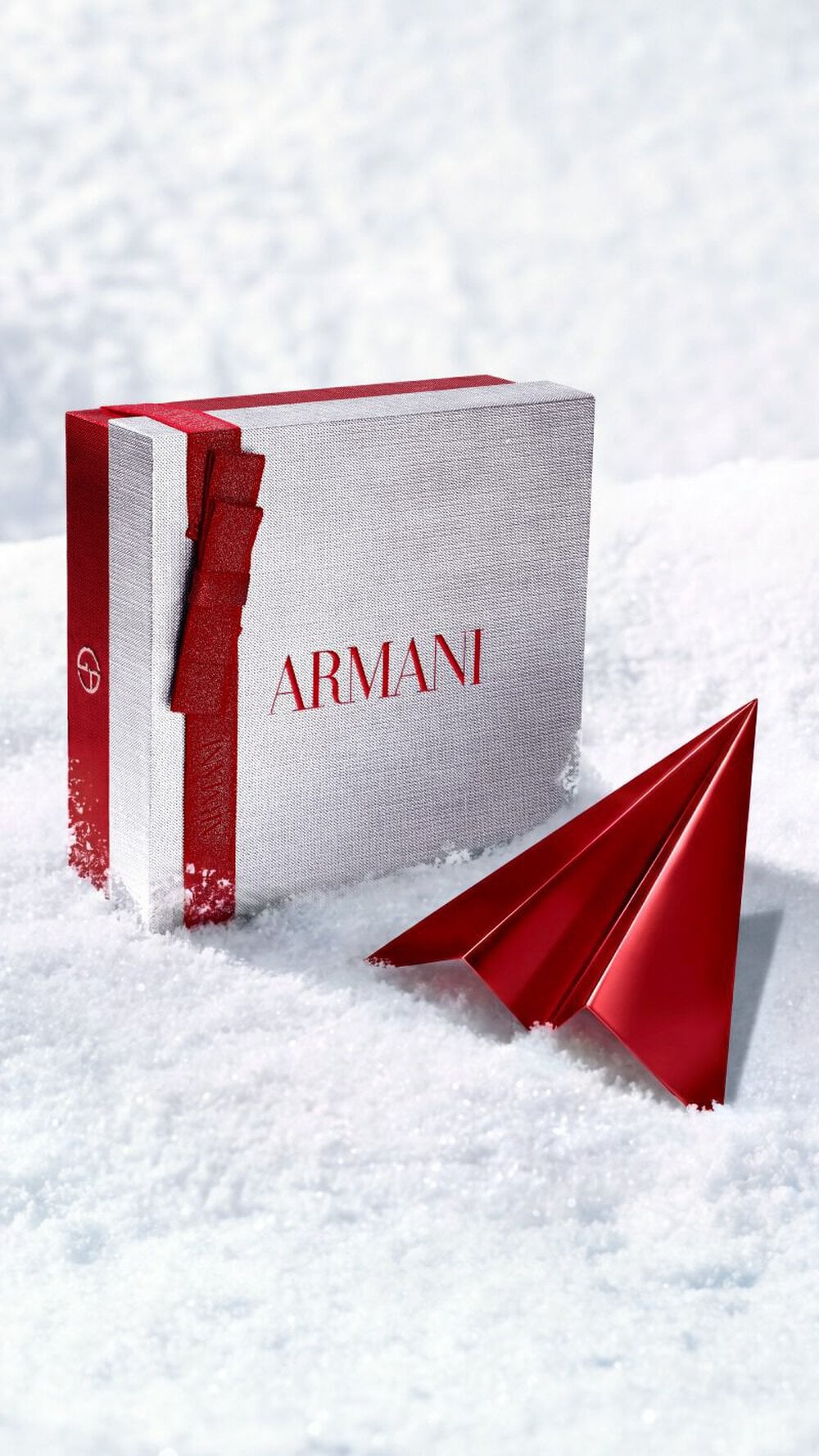 Armani beauty silver gift box with red paper plane for complimentary holiday delivery.