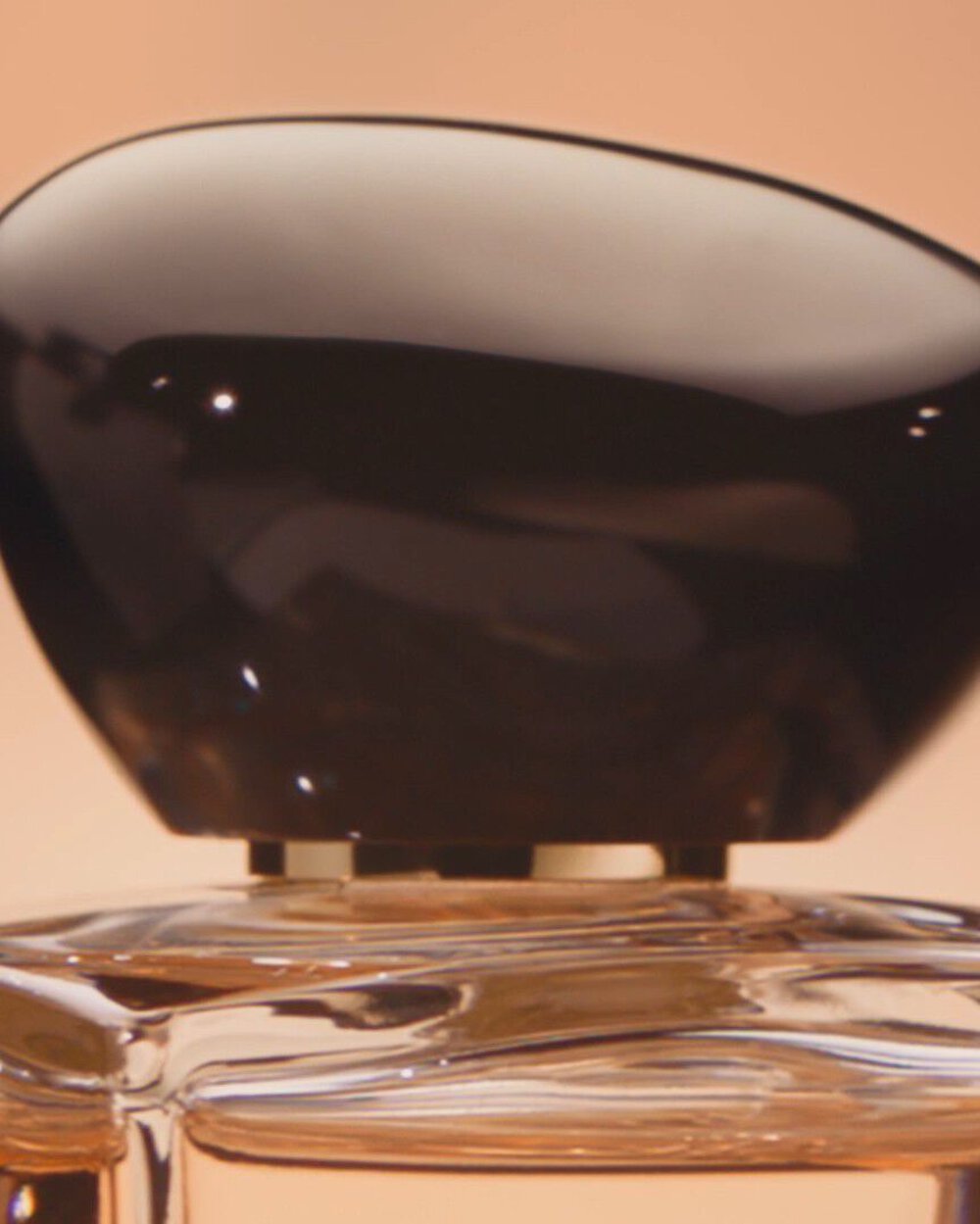 Armani/Prive: elegant close-up of the sculptural black cap and faceted glass bottle, showcasing the fragrance’s refined and contemporary design.