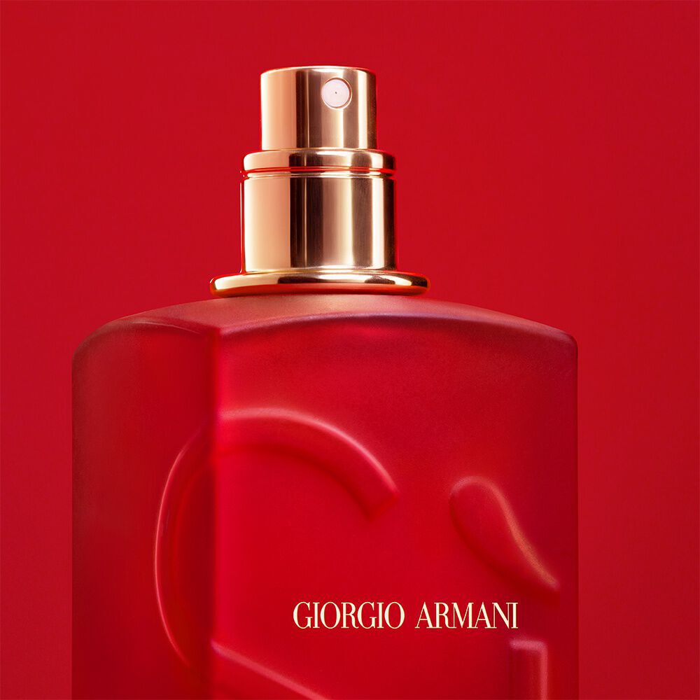 Close-up of the Giorgio Armani Si red bottle spray nozzle on a red background.