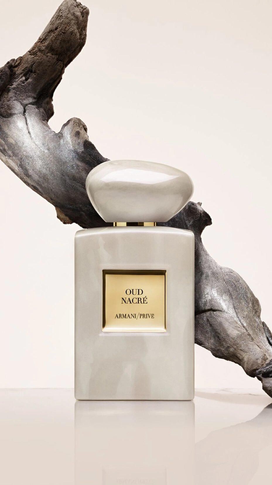 Armani Prive Oud Nacre perfume bottle with flowing Oud in the back