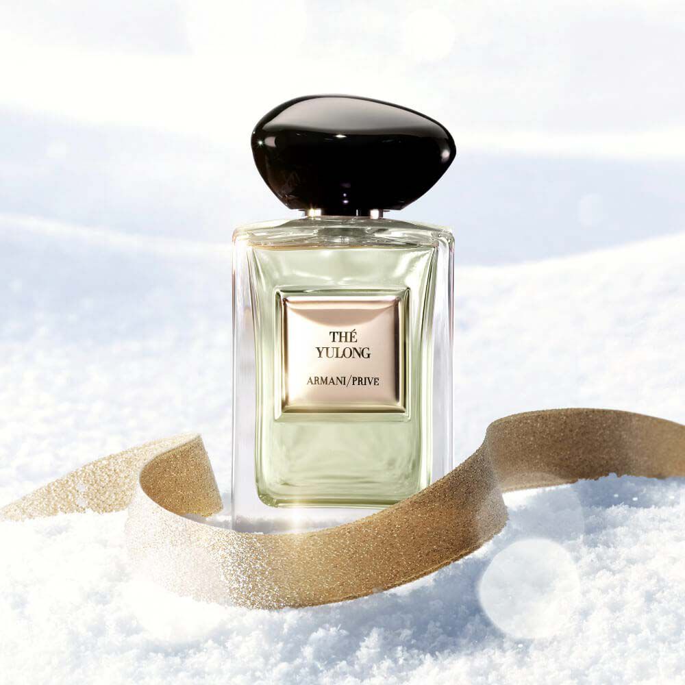 Armani Prive Les Eaux The Yulong Holiday gift set, open gold box on a warm background revealing the eau de parfum bottle, miniature fragrance and Scented soap nestled inside.