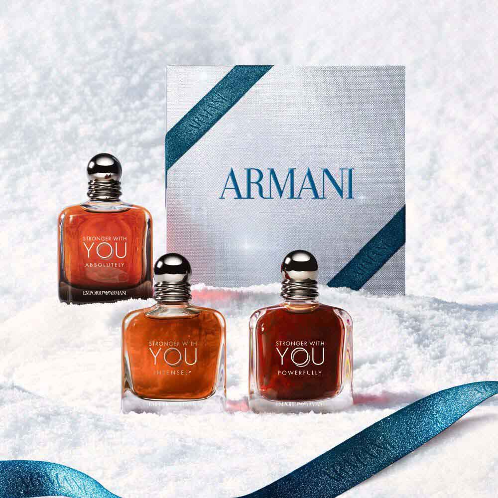 Stronger with you  bottles displayed alongside the Armani gift box and blue ribbon on a marble winter surface, holiday gift set presentation.