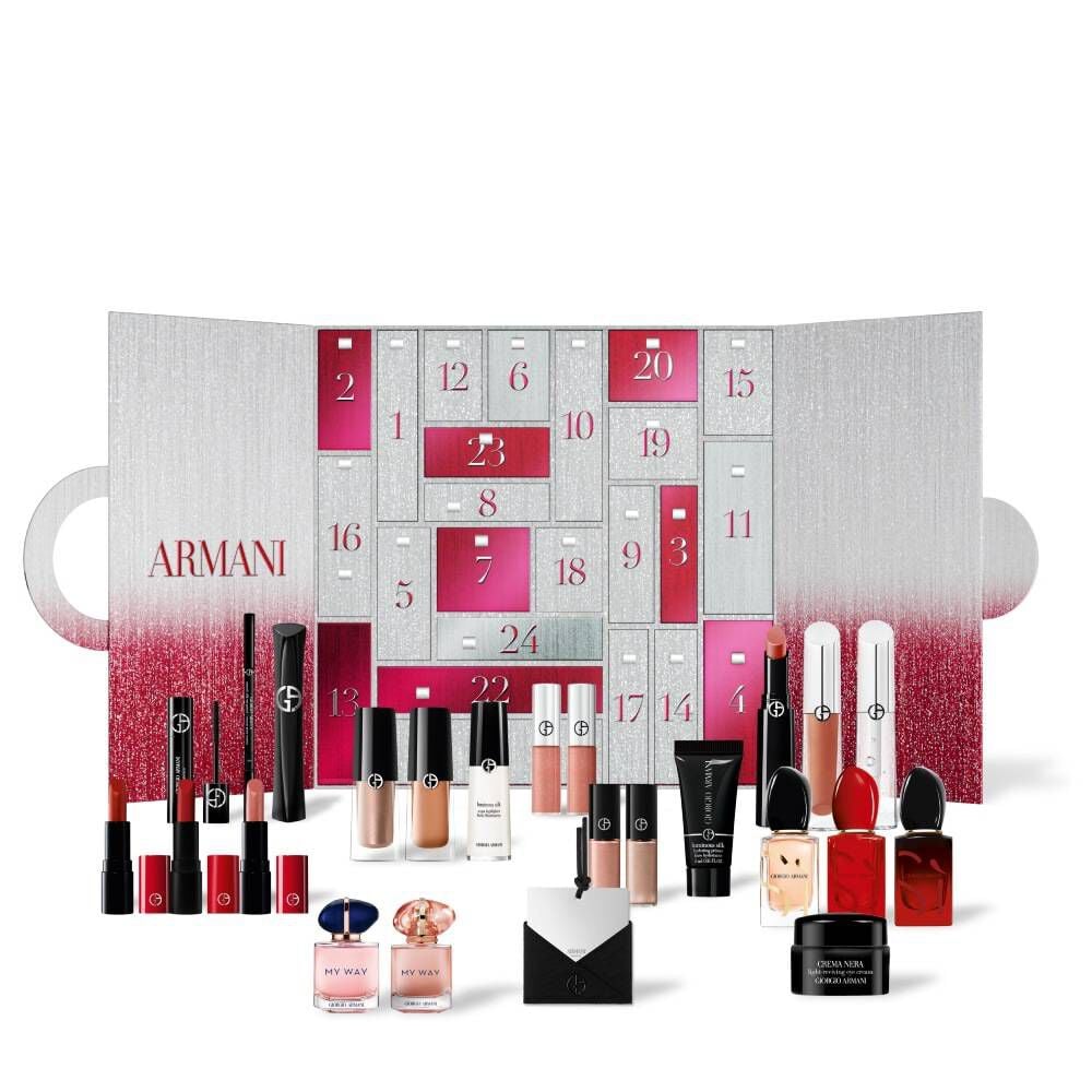 An open Giorgio Armani advent calendar with a wide array of makeup products, fragrances, and mini beauty essentials arranged in front of its numbered doors.	