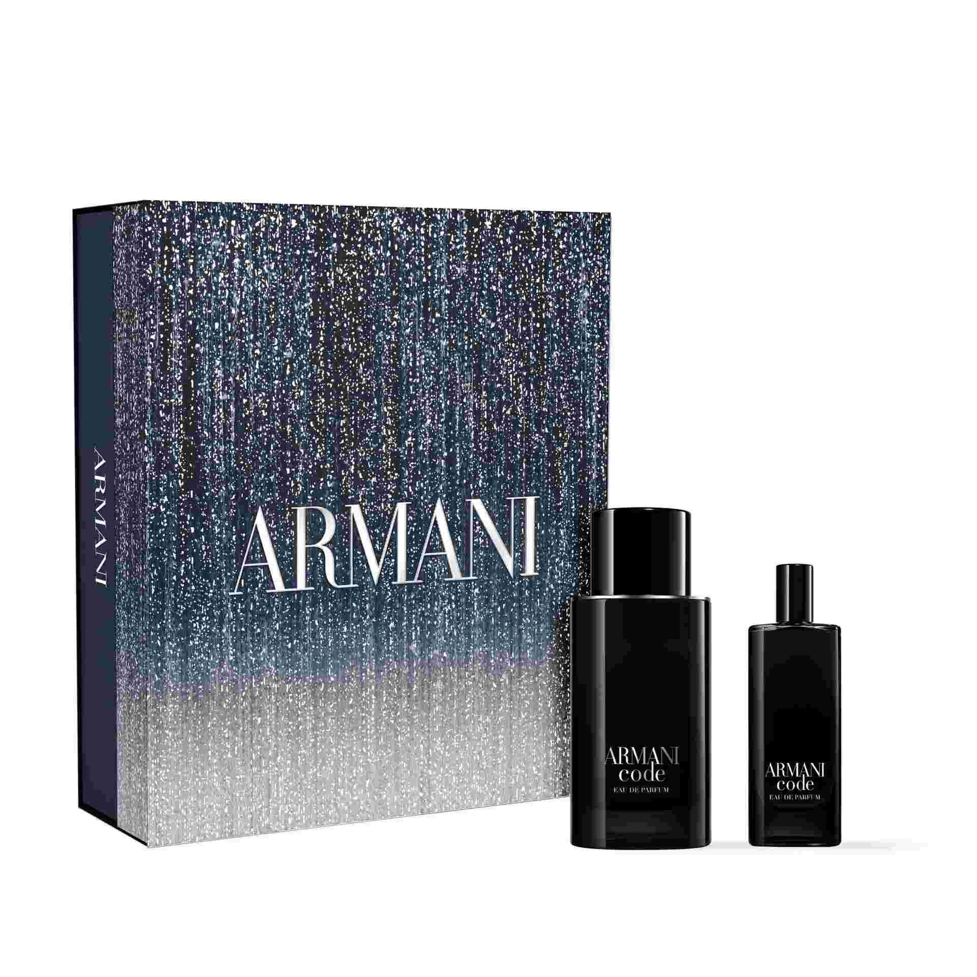 A boxed Armani Code gift set is displayed, featuring a stylish, dark blue box with a gradient design and the ARMANI logo. In front of the box are two products: a 50 ml and a 15 ml bottles of Armani Code Eau de Parfum.