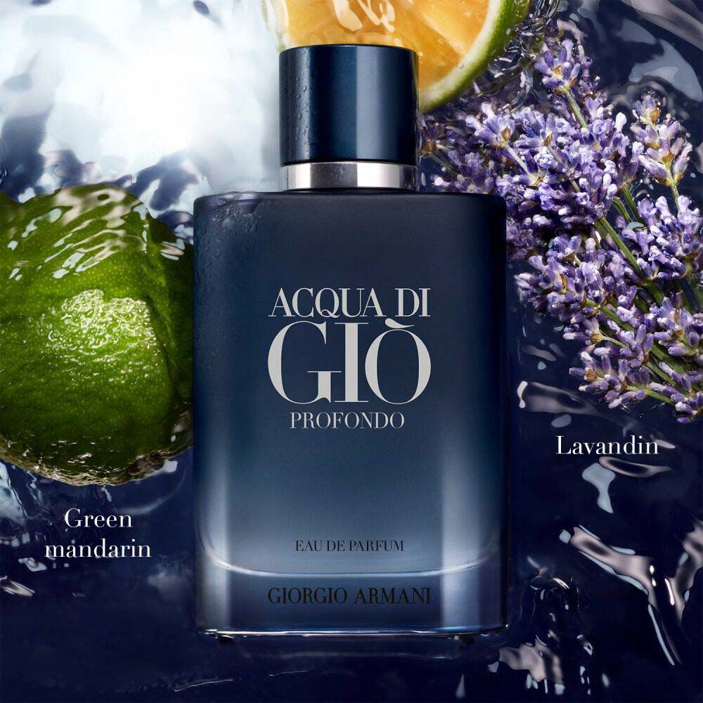 Acqua di Gio Profondo Eau de Parfum by Giorgio Armani, deep blue bottle surrounded by green mandarin and lavandin flowers on a water-drenched surface — men's aquatic fragrance.