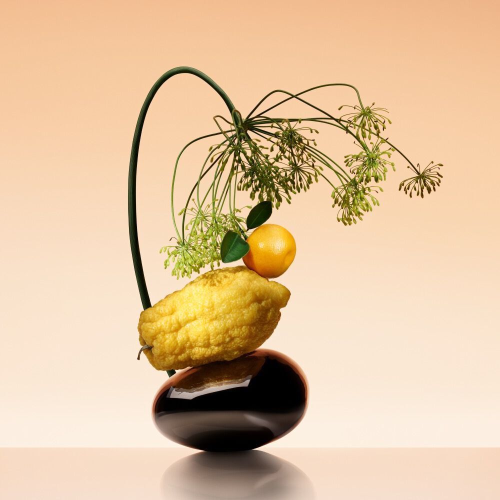 Armani/Prive Orange Mediterranee bottle in an artistic ikebana composition with citron and fennel, exuding elevated luxury.