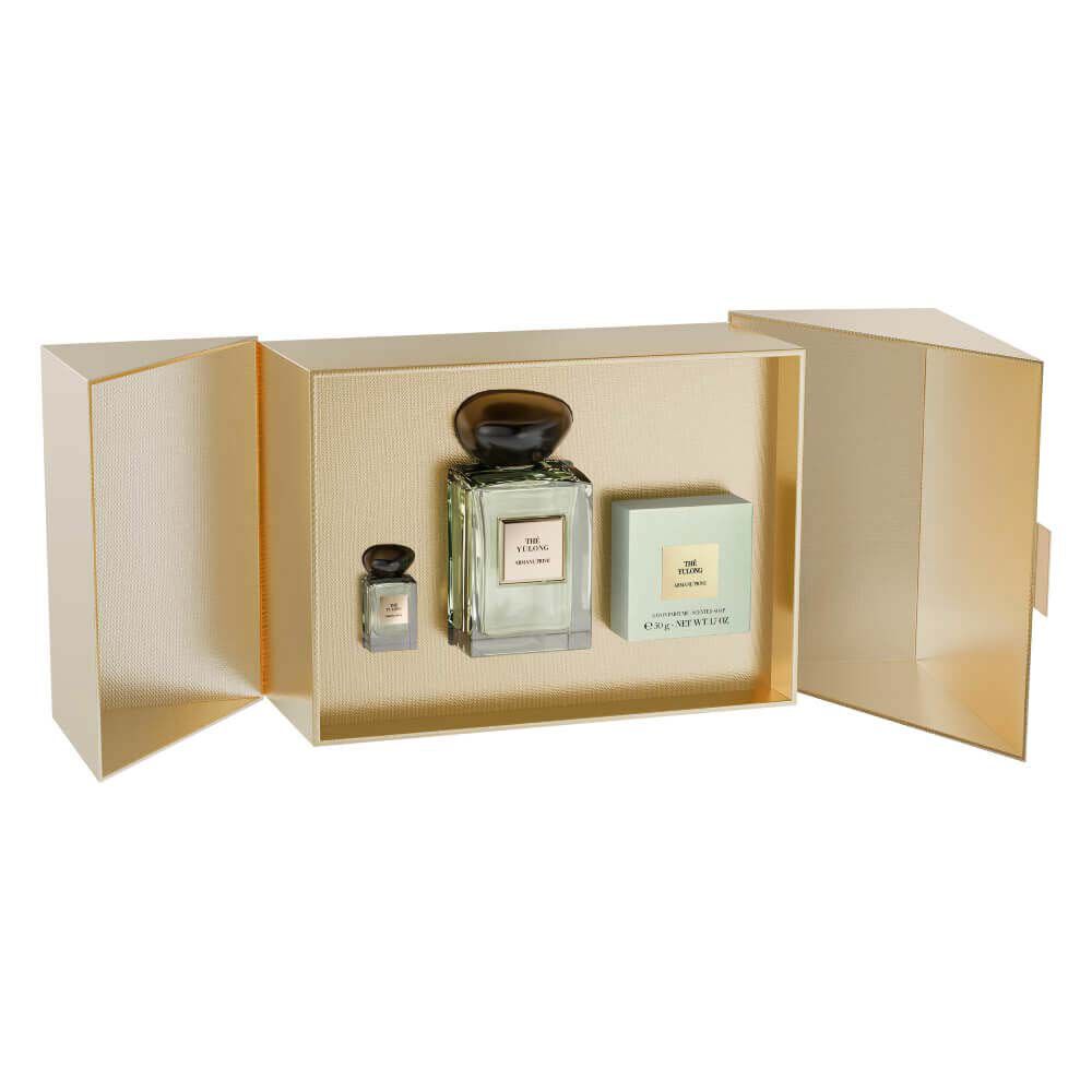 Armani Prive Les Eaux The Yulong eau de parfum, transparent rectangular glass bottle with black rounded cap, on a white snowy surface with a golden ribbon.