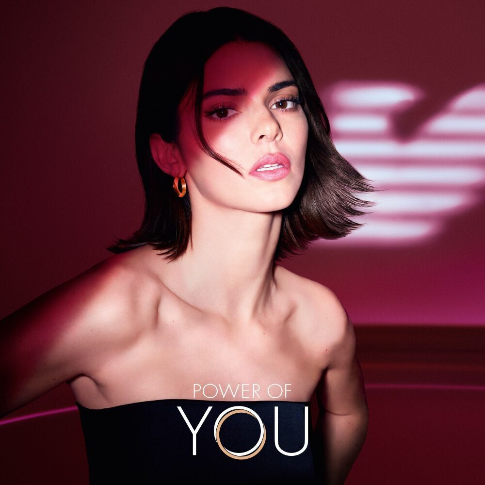 Kendall Jenner with illuminated ruby wings of light, symbolizing feminine power and radiance.
