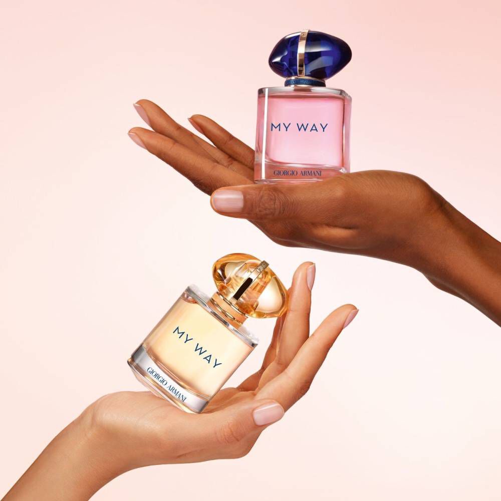 Two hands holding Giorgio Armani My Way Sunny Vanilla and My Way Eau de Parfum bottles in different colors, emphasizing diversity and the range of scents.