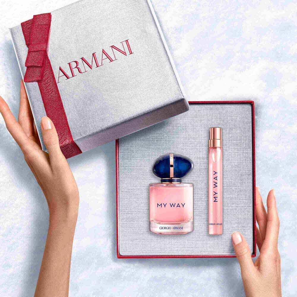 Hands unveiling a ruby-ribboned white Armani gift box with My Way Eau de Parfum 50ml and 10ml — a refined women's floral fragrance gift set.