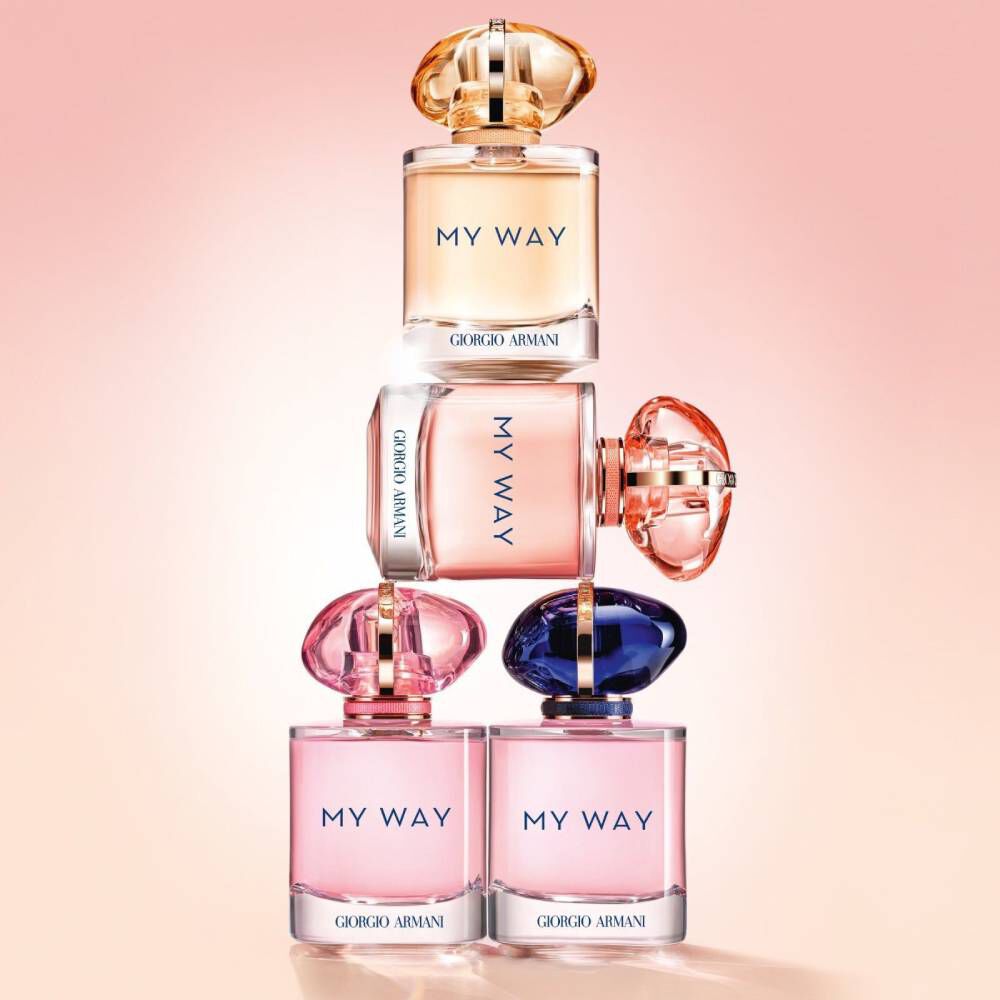 Stack of four Armani My Way perfume bottles in various shades and sizes, illustrating the collection’s variety and playful design.