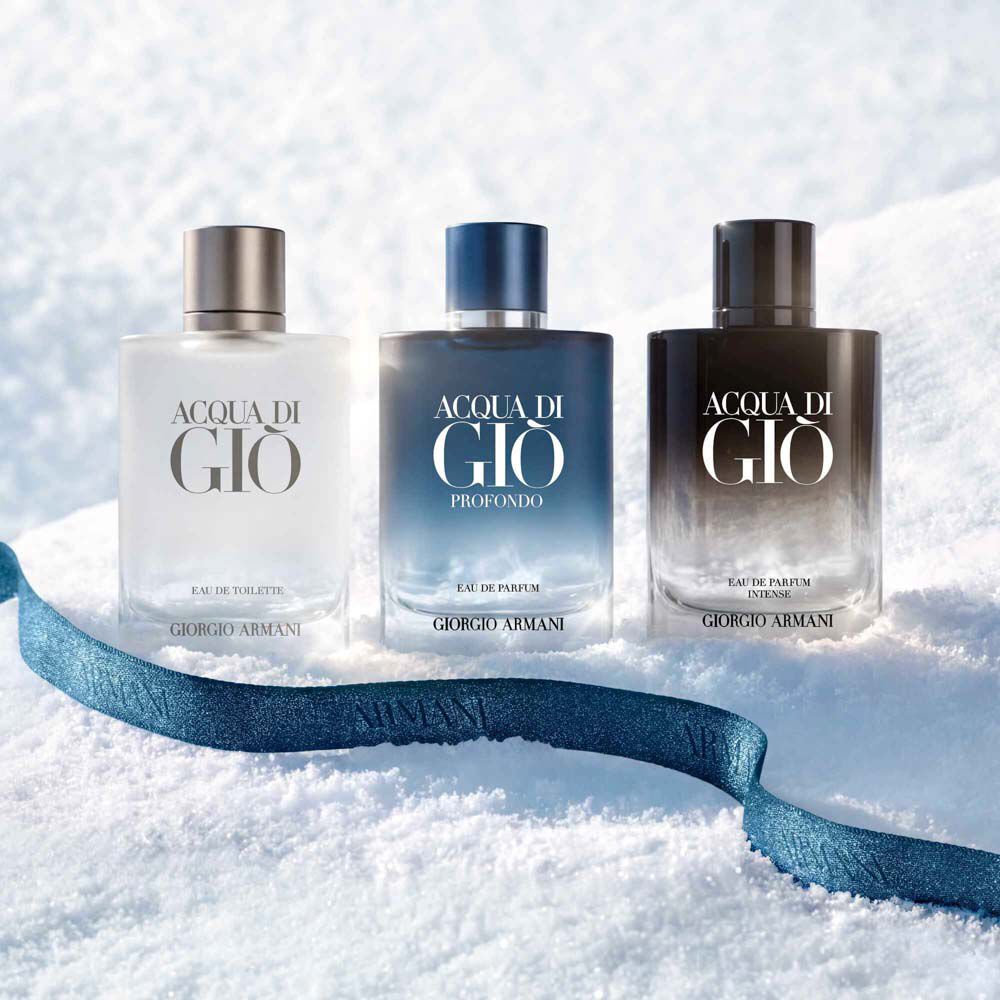 Giorgio Armani Acqua di Gio Eau de Toilette, Acqua di Gio Profondo Eau de Parfum and Acqua di Gio Eau de Parfum Intense — three signature clear glass bottles in varying shades of blue displayed side by side, showcasing the complete Acqua di Gio fragrance collection.