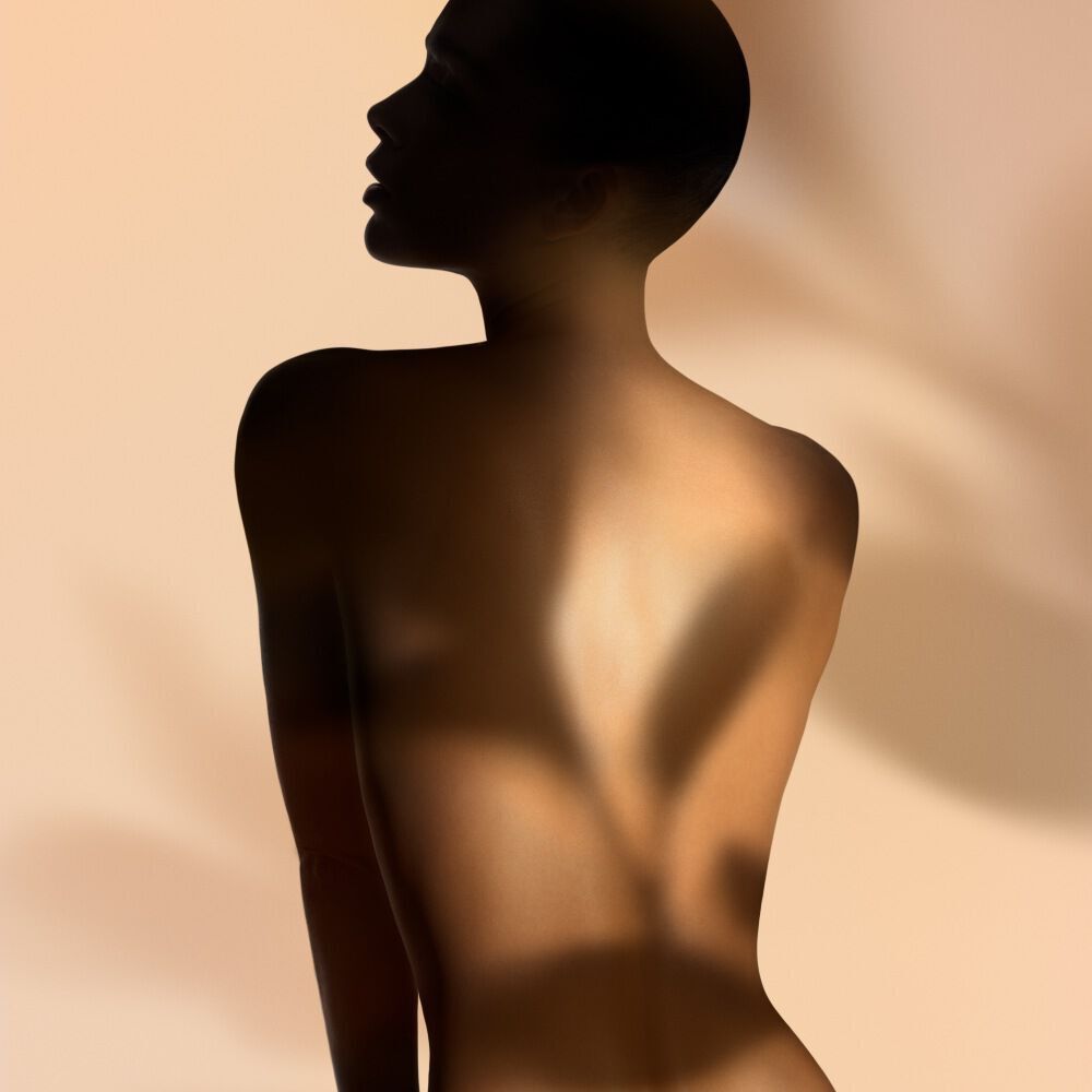 Silhouette of a woman against a warm background, representing the beauty and elegance of Armani/Prive Orange Mediterranee.