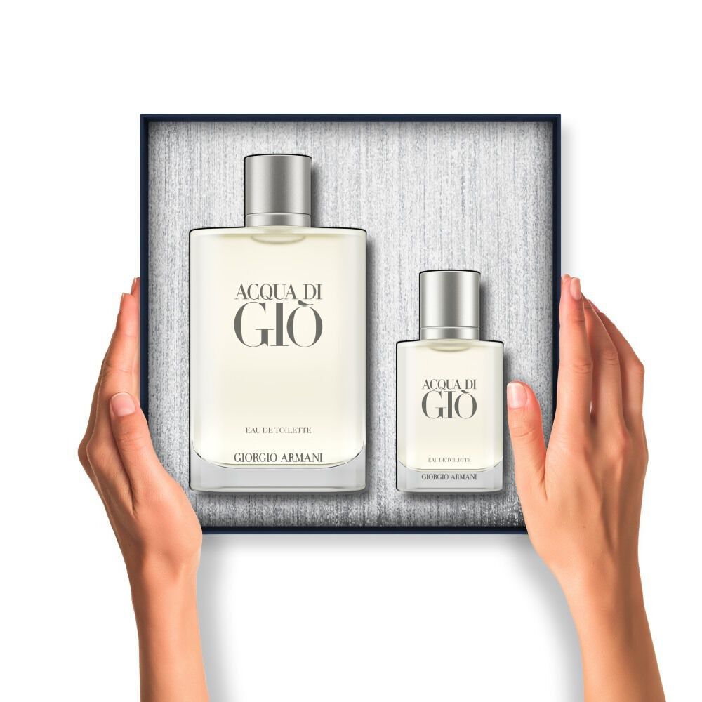 Hands holding an open gift box containing two frosted bottles of Acqua di Gio Eau de Toilette.