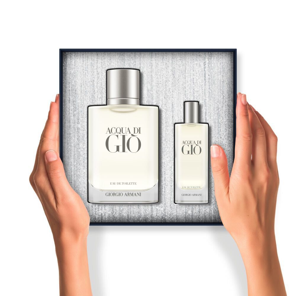 Hands holding an open gift box containing two frosted bottles of Acqua di Gio Eau de Toilette.