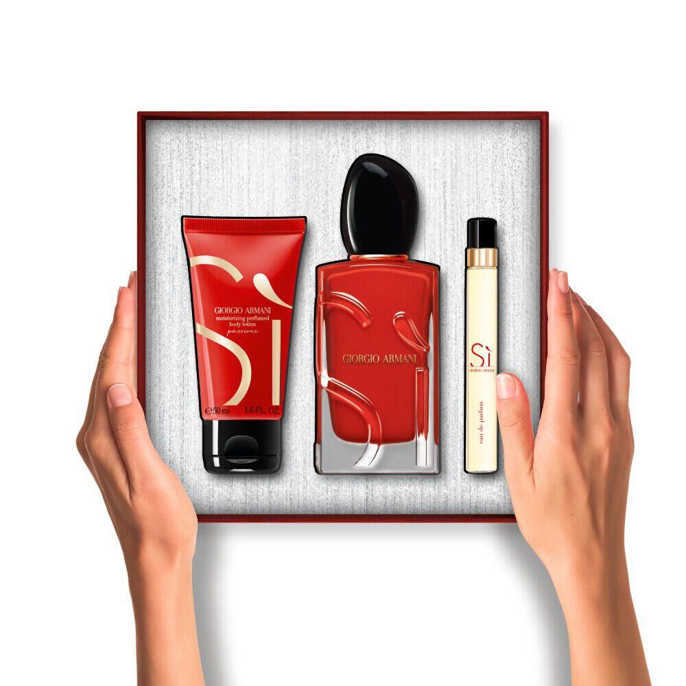 Hands holding a Si Passione Eau de Parfum 100ml, Si Passione Eau de Parfum Boday lotion 50ml and Si Passione Eau de Parfum 10ml  set inside a gift box.	