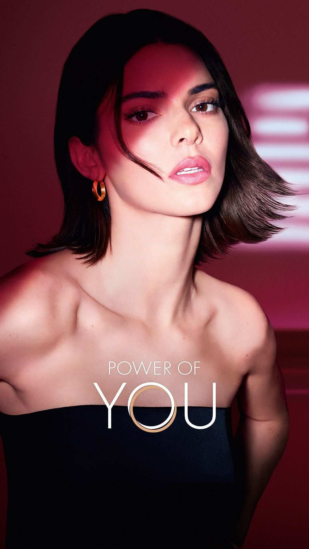 Kendall Jenner with illuminated ruby wings of light, symbolizing feminine power and radiance.