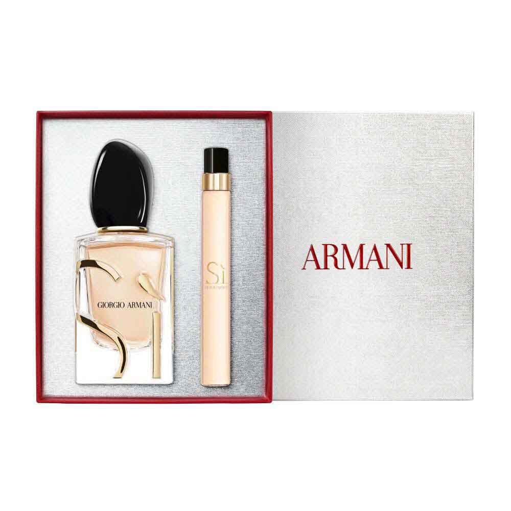 Si Eau de Parfum 50ml and 10ml gold-toned bottles displayed alongside an open white Armani gift box with red ribbon — women's floral fragrance gift set, white background.