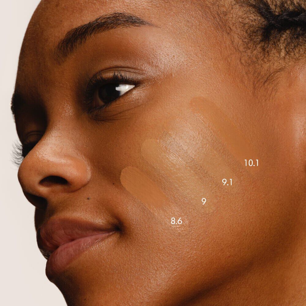 Close-up of a model's cheek with five swatches of LUMINOUS SILK FOUNDATION in shades