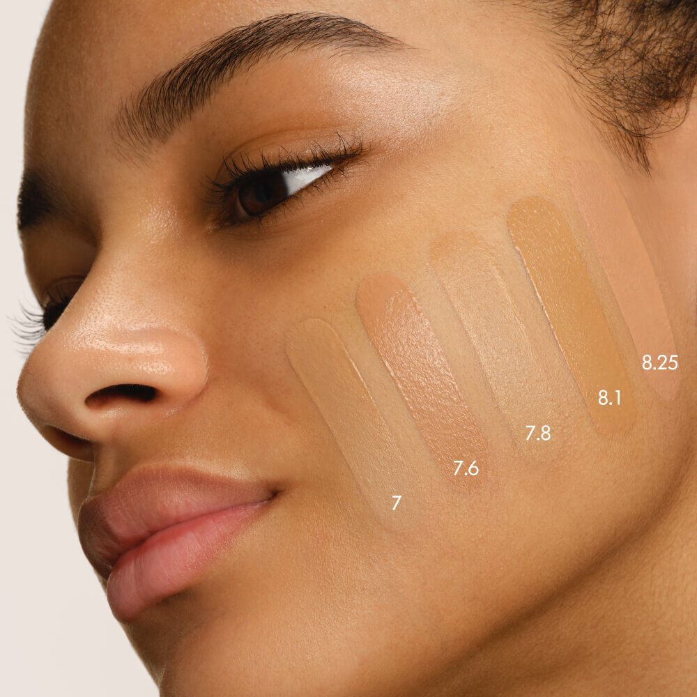 Close-up of a model's cheek with five swatches of LUMINOUS SILK FOUNDATION in shades