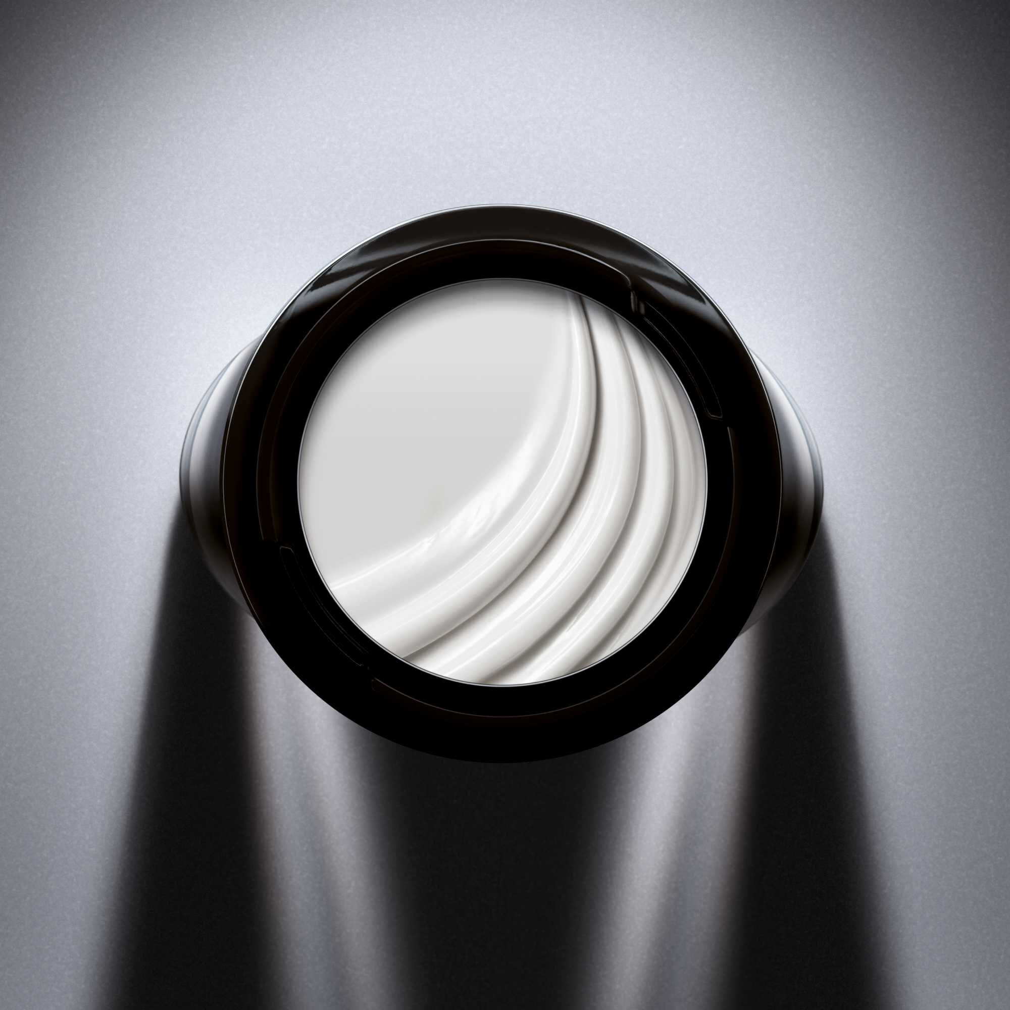 Top view into a jar of white CREMA NERA Sheer Cream.