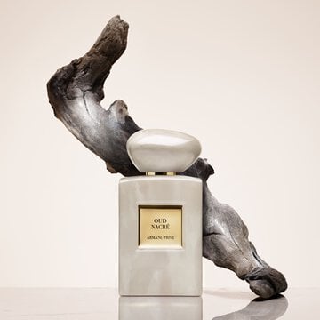 Armani Prive Oud Nacre perfume bottle with flowing Oud in the back
